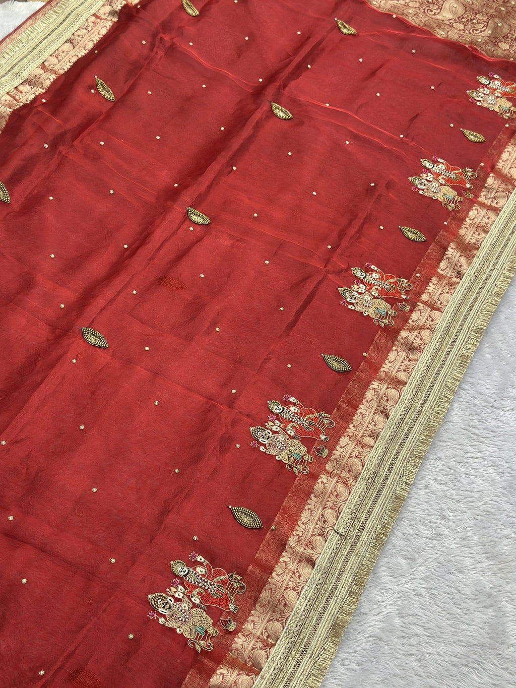 Red tissue saree body with zari leaf buttis and Ganesh Laxmi border motifs