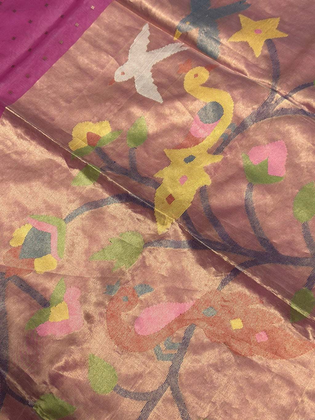 Close-up of woven bird and floral motifs on rosewood pink Jamdani