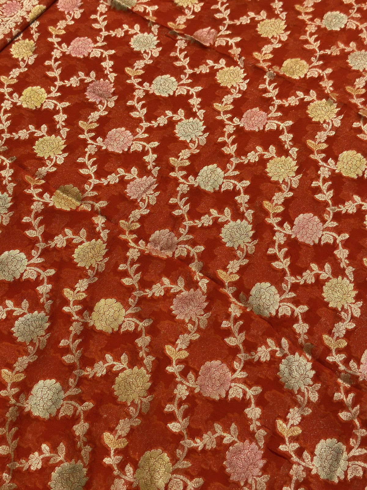 Close-up of woven floral motifs on orange Khaddi Georgette