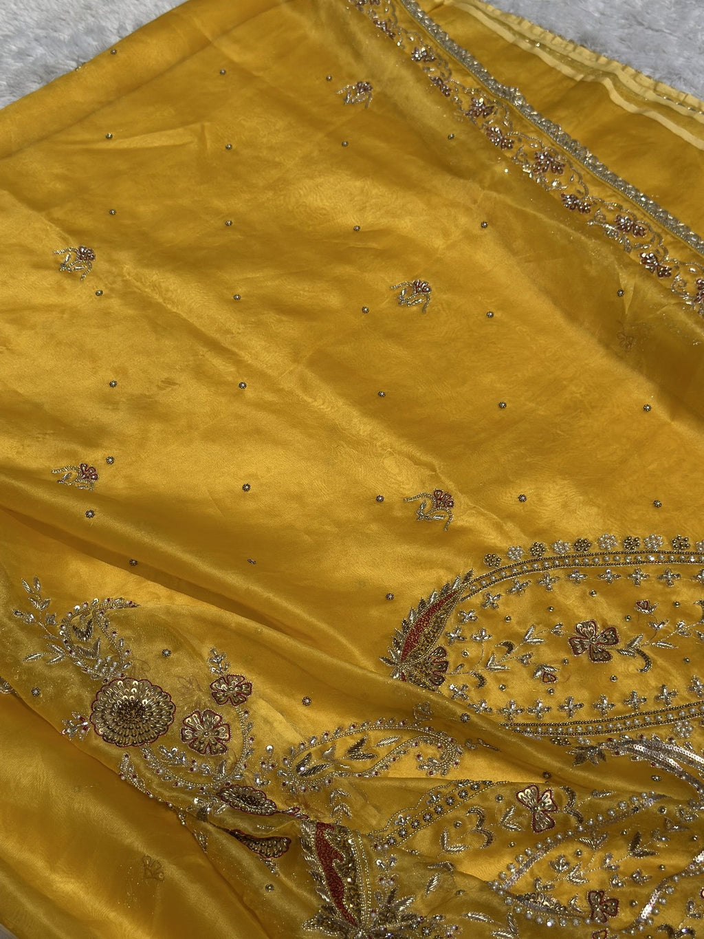 Suvarna Noor yellow Kora saree draped, showing paisley embroidery and border