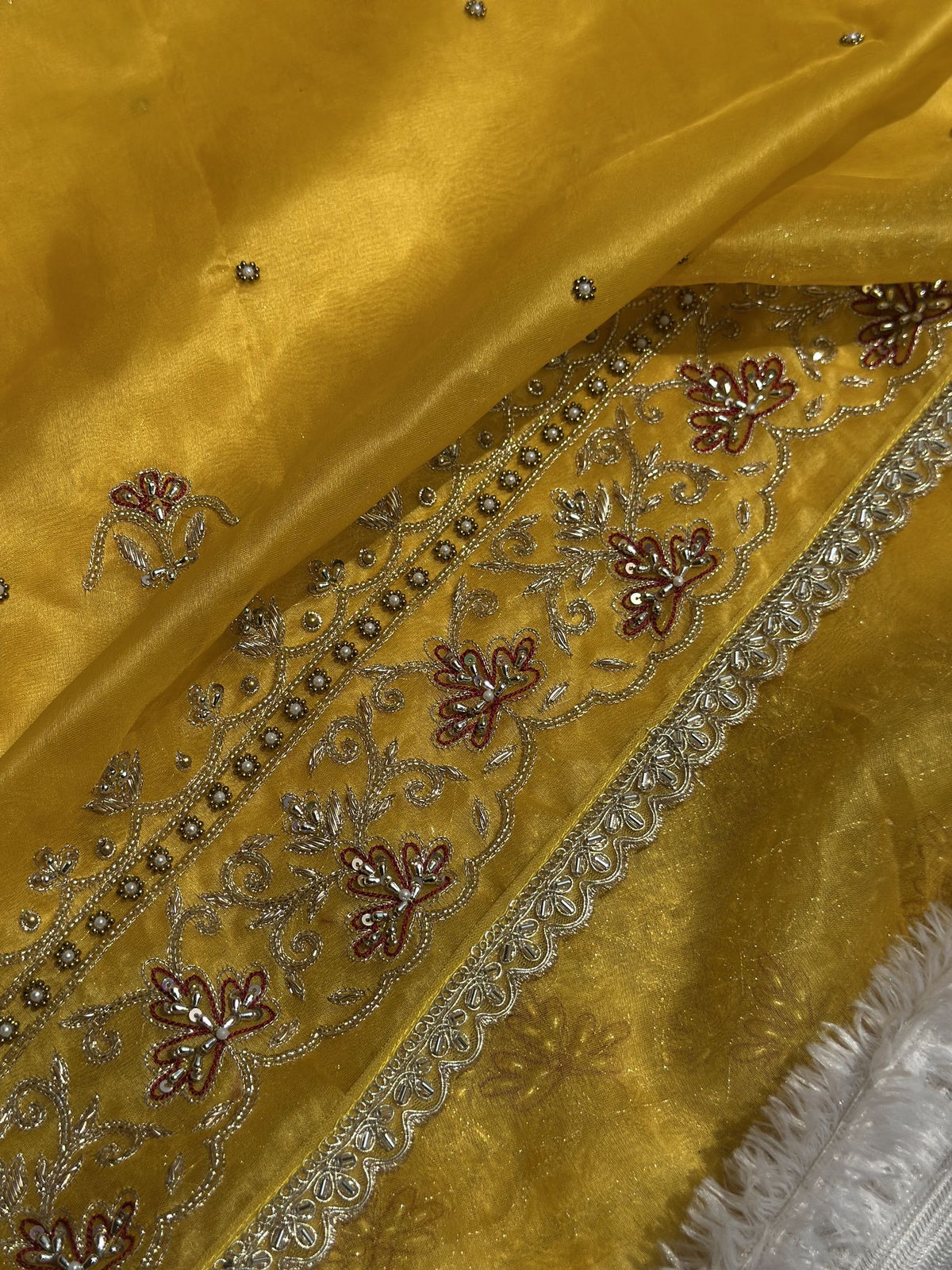 Embroidered floral border detail on Suvarna Noor yellow Kora saree