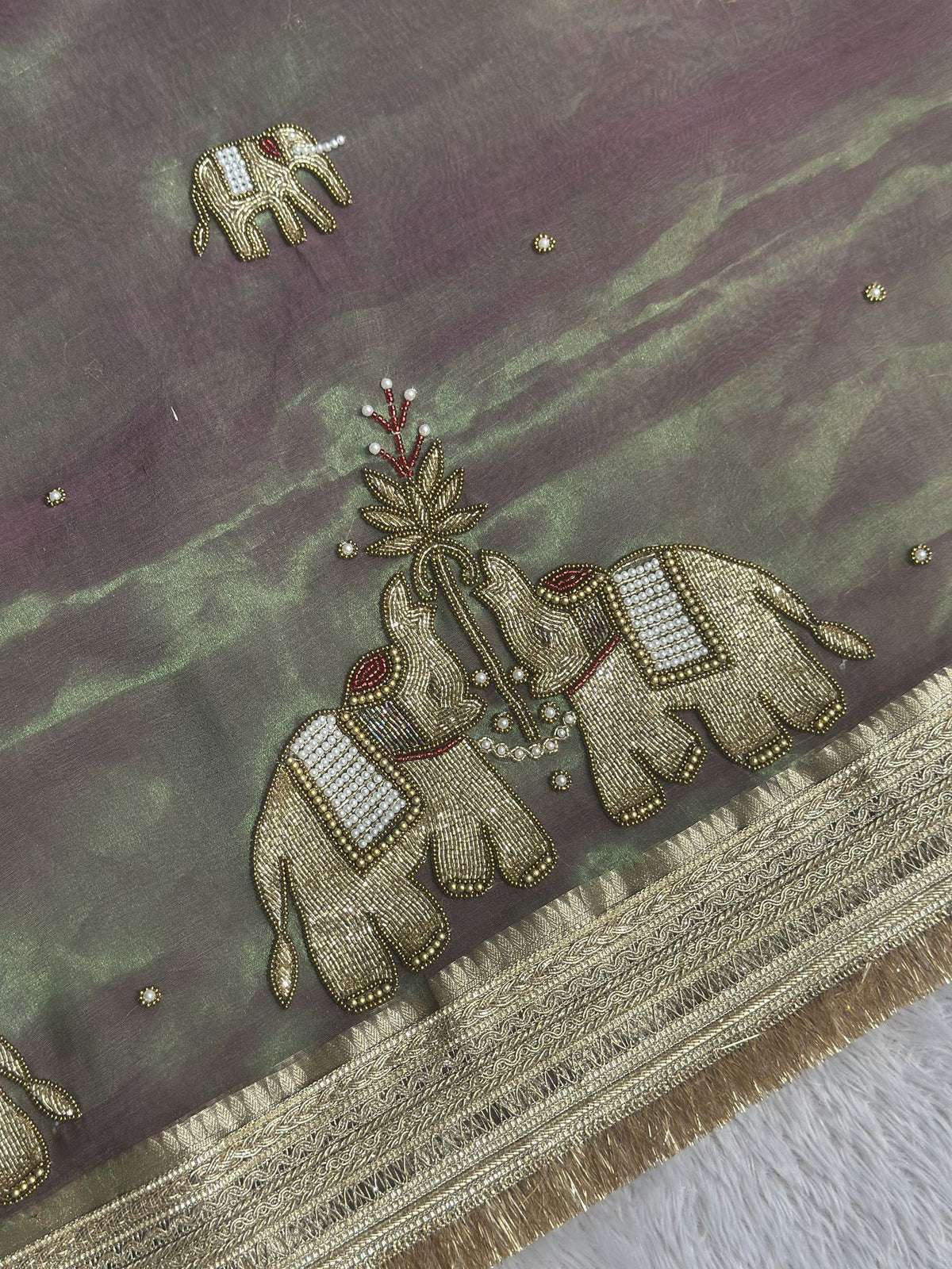 Gold zari elephant motif close-up on Suvarna Hatti mauve green saree
